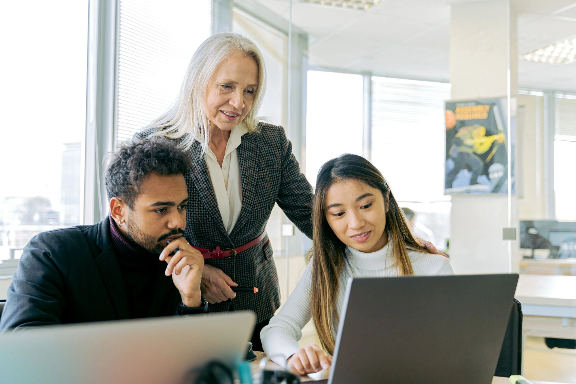 A manager supports two team members during a collaborative learning session