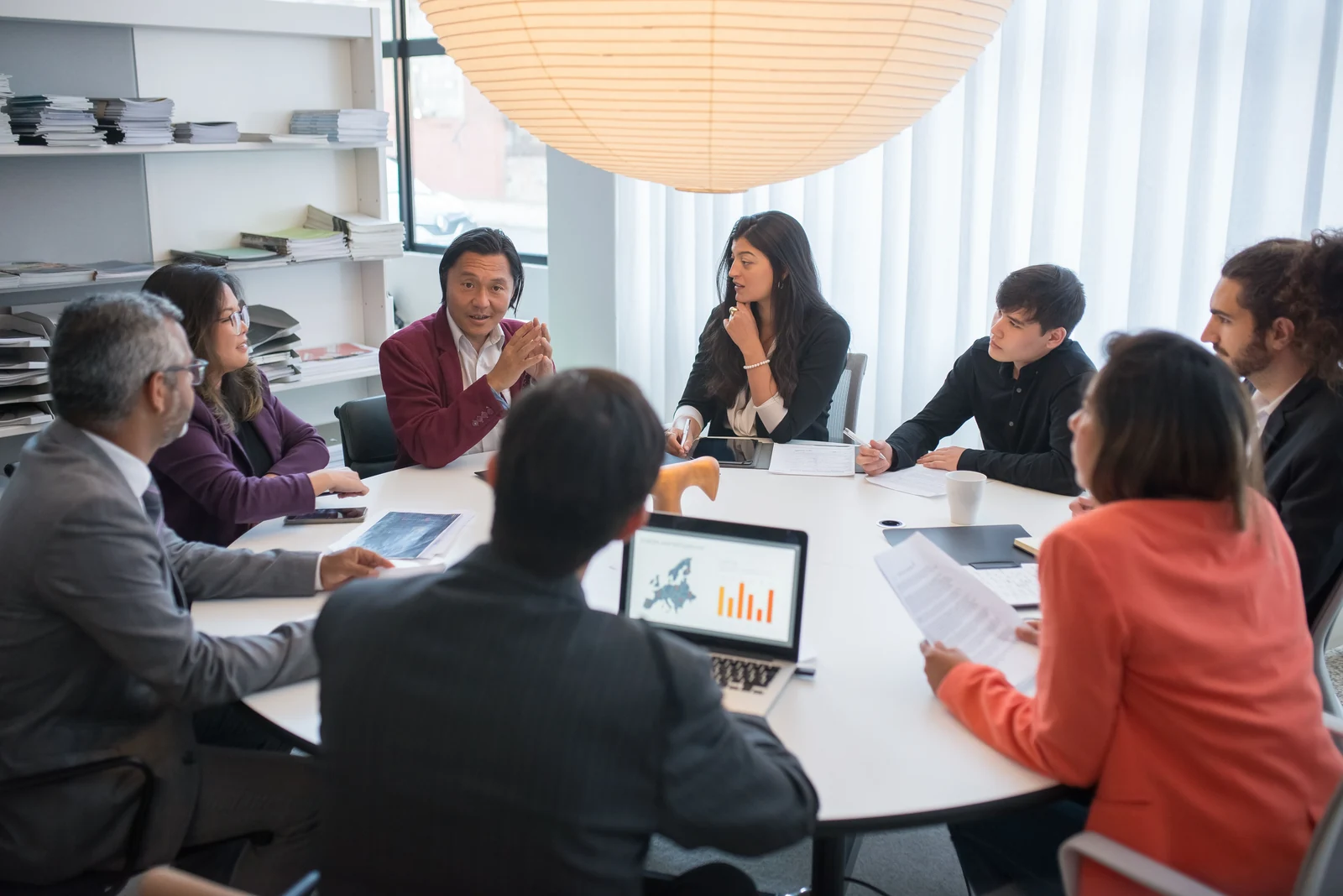 A leader focused on a conversation with colleagues in a bright office